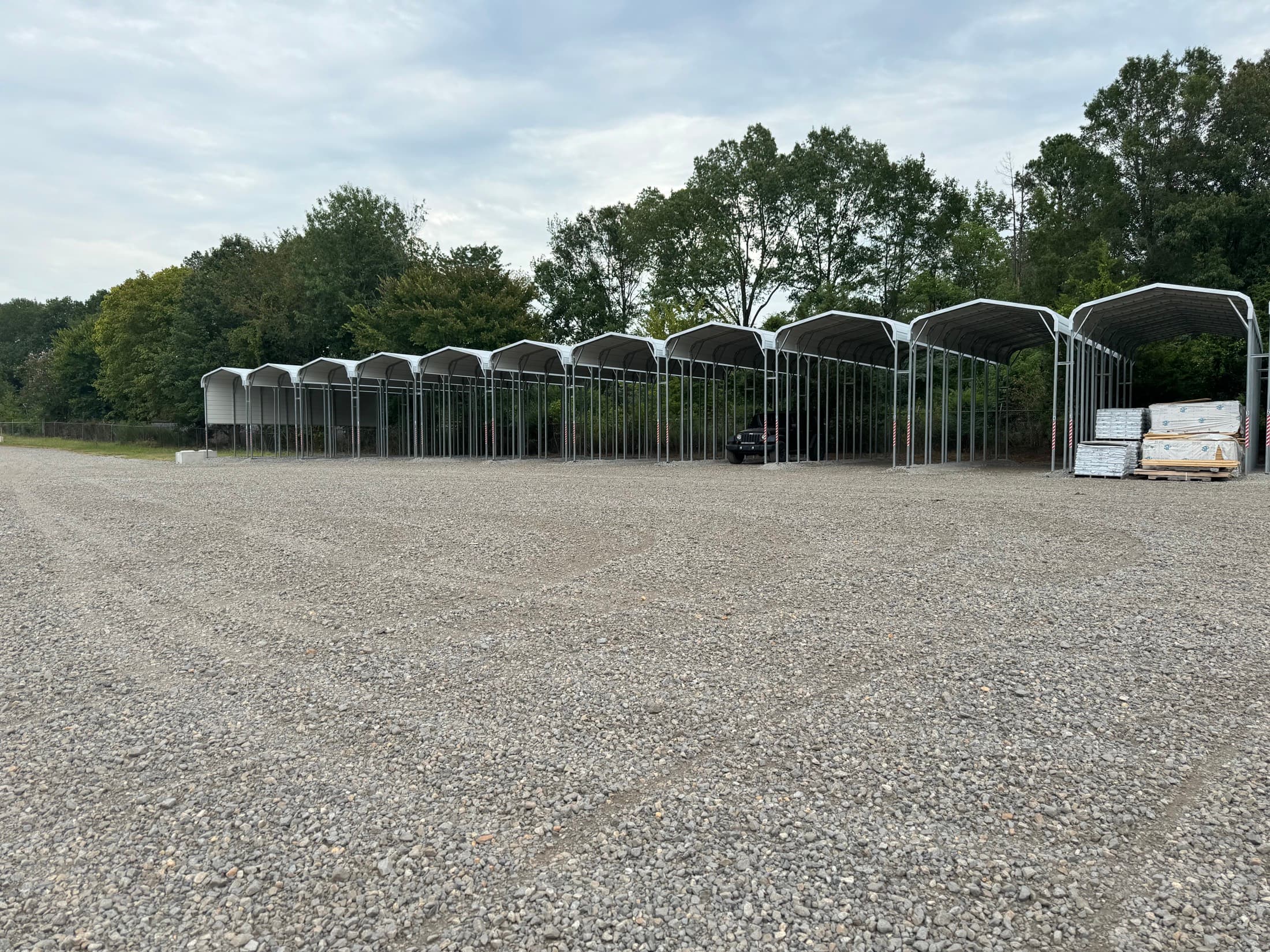 Covered parking canopies over the gravel lot at MidArk Outside Storage