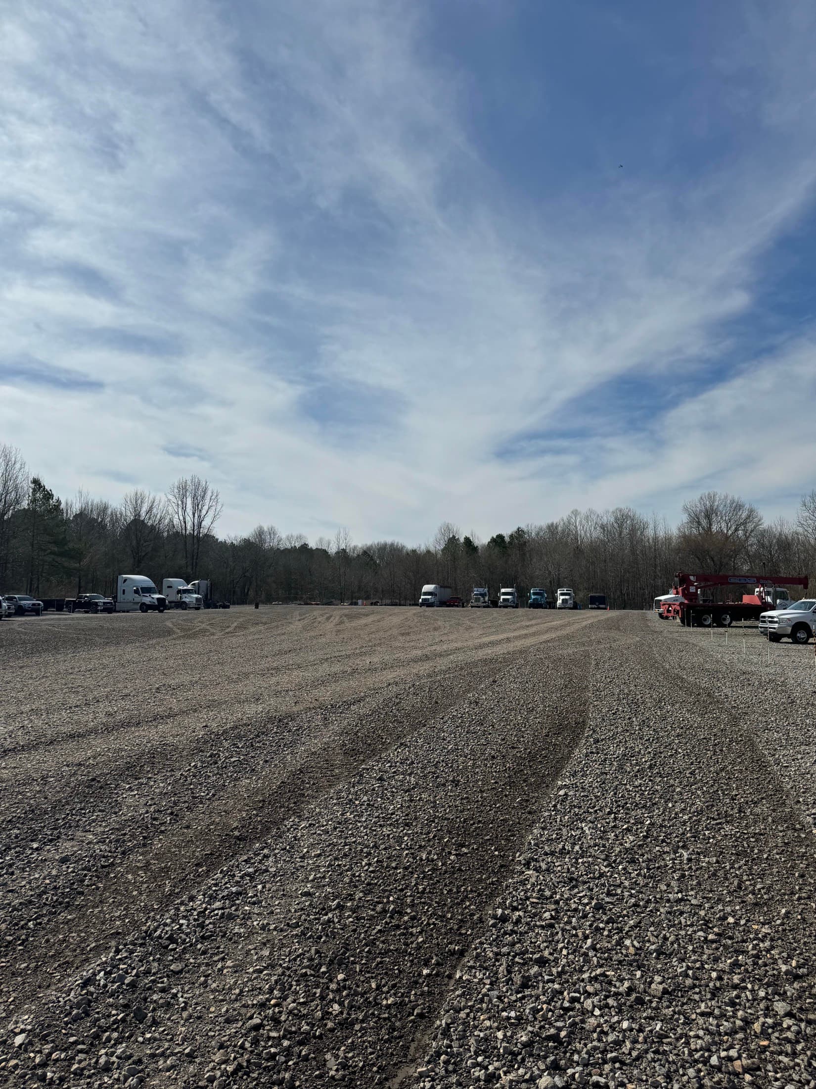 Trucks and trailers parked along the tree line at the MidArk gravel yard